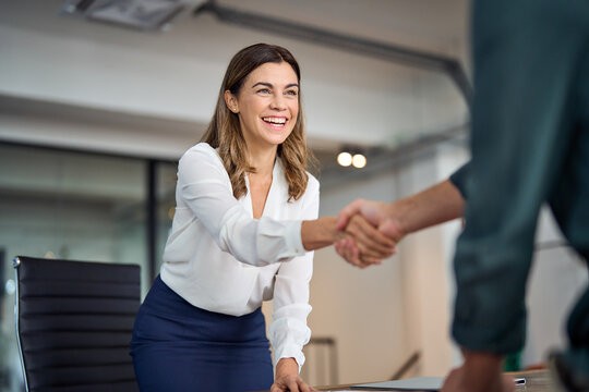 A smiling woman shaking hands with her new colleague